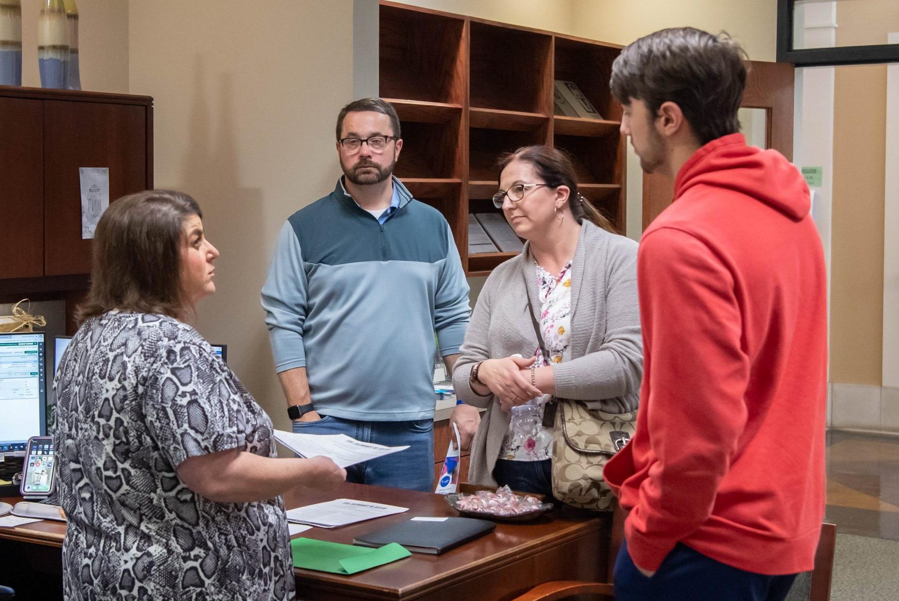 Student and parents speaking with financial aid representative.